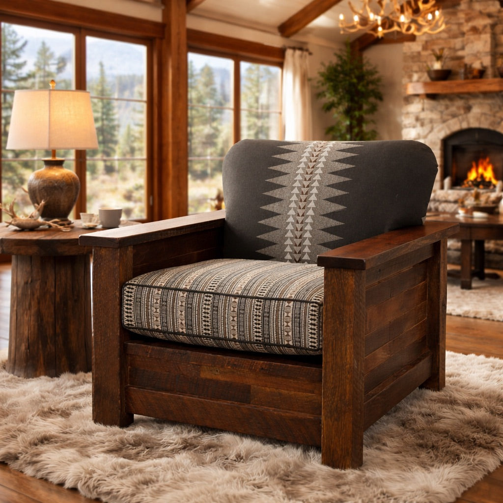 American-made reclaimed barnwood lounge chair with patterned fabric cushions, staged in a bright luxury lodge living room with high beam ceilings, faux fur rug, stone fireplace, and large sunlit windows.