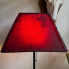 Rectangle red rawhide lamp shade with the light on 