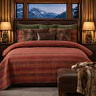 Rushmore Cabin quilted bedding set styled in a luxury lodge bedroom with leather and fur throw pillows, euro shams, wood nightstands, warm lighting, and mountain view windows