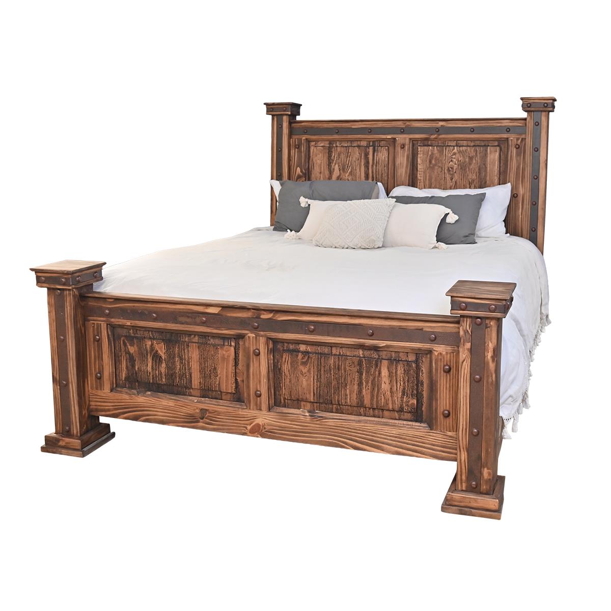 A rustic wooden bed frame with a tall paneled headboard and footboard, shown dressed with white bedding and gray accent pillows on a plain white background.