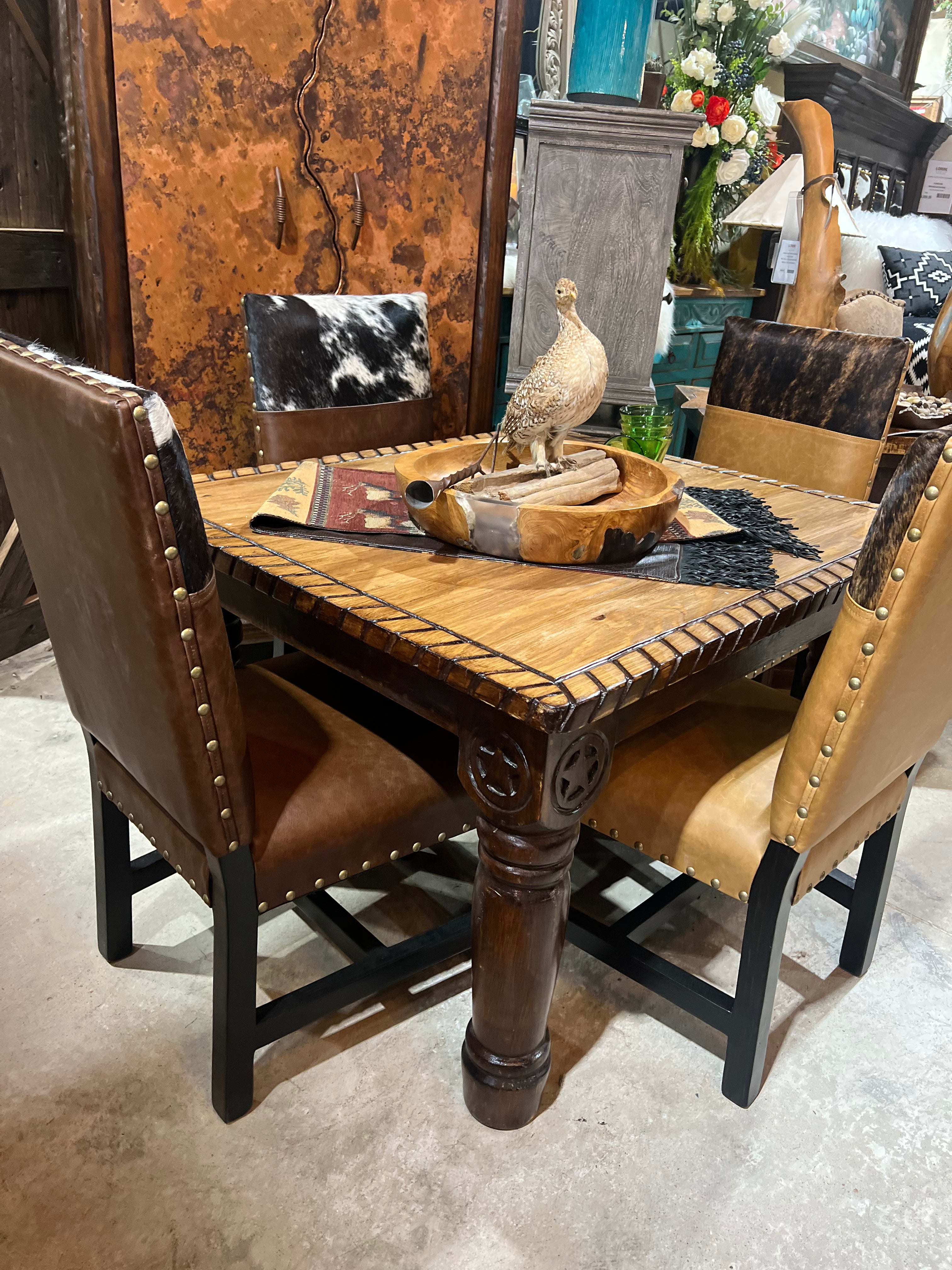 Wooden dining table with rustic decor and chairs in a showroom setting - Your Western Decor
