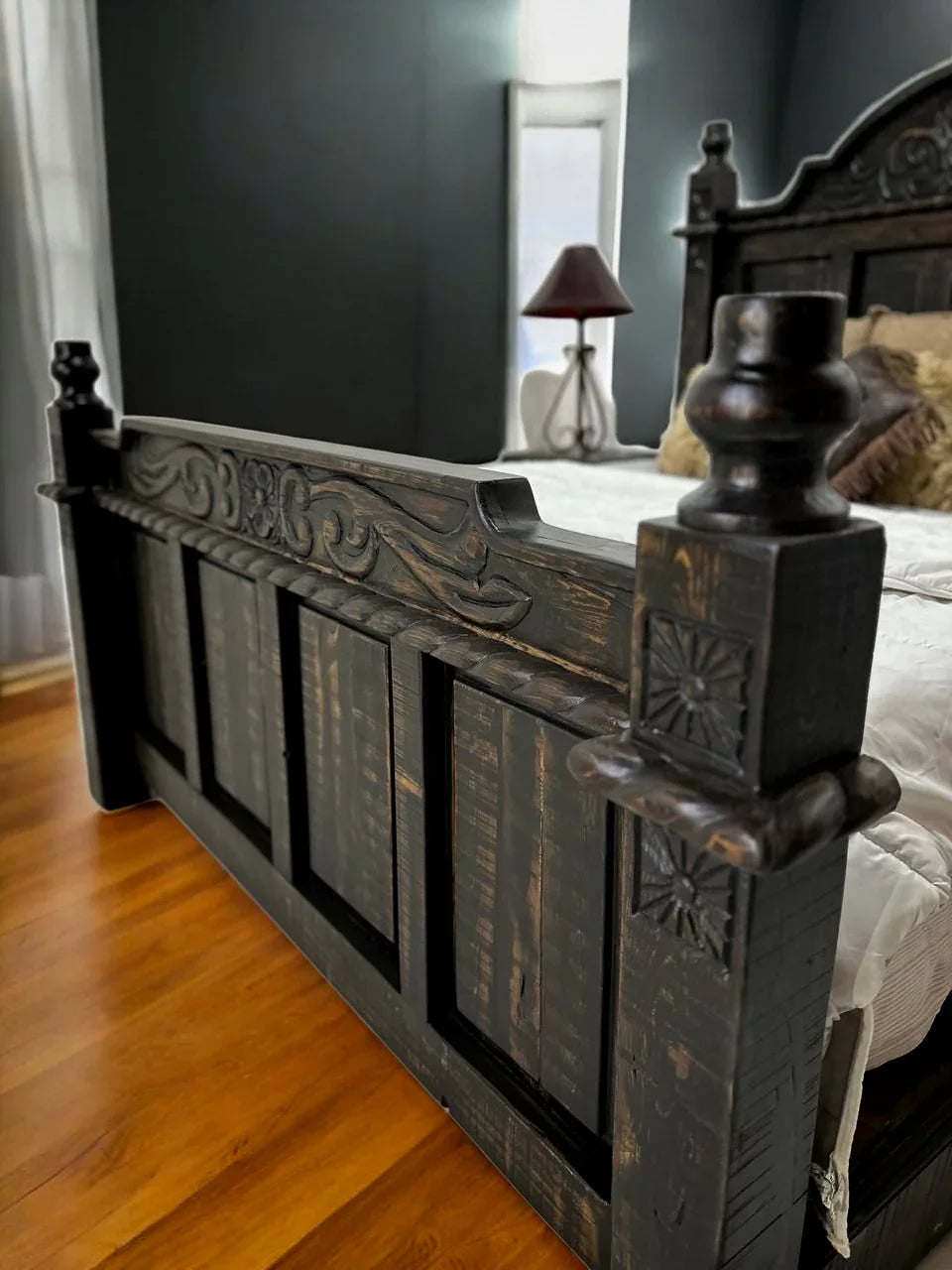 Decorative wooden bed frame in a bedroom setting with a lamp and window in the background - Your Western Decor
