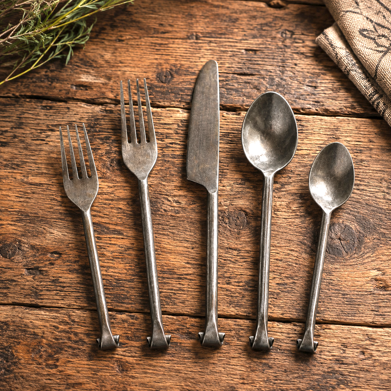 Forged Iron Flatware Set displayed on reclaimed rustic wood tabletop.