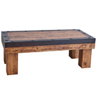 A rustic rectangular coffee table made of weathered brown wood with a dark charcoal-black metal top border and metal rivets