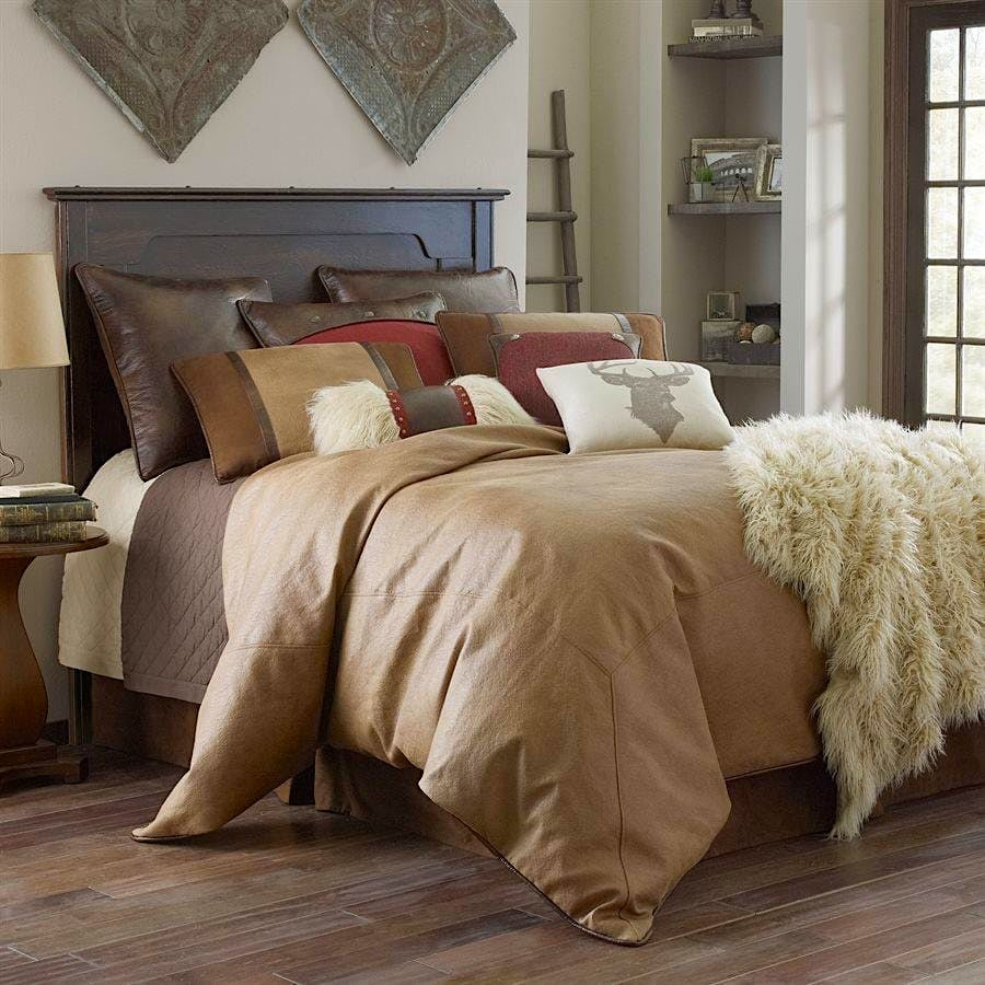 Bedroom with a bed featuring brown bedding and decorative pillows, with a side table and lamp.