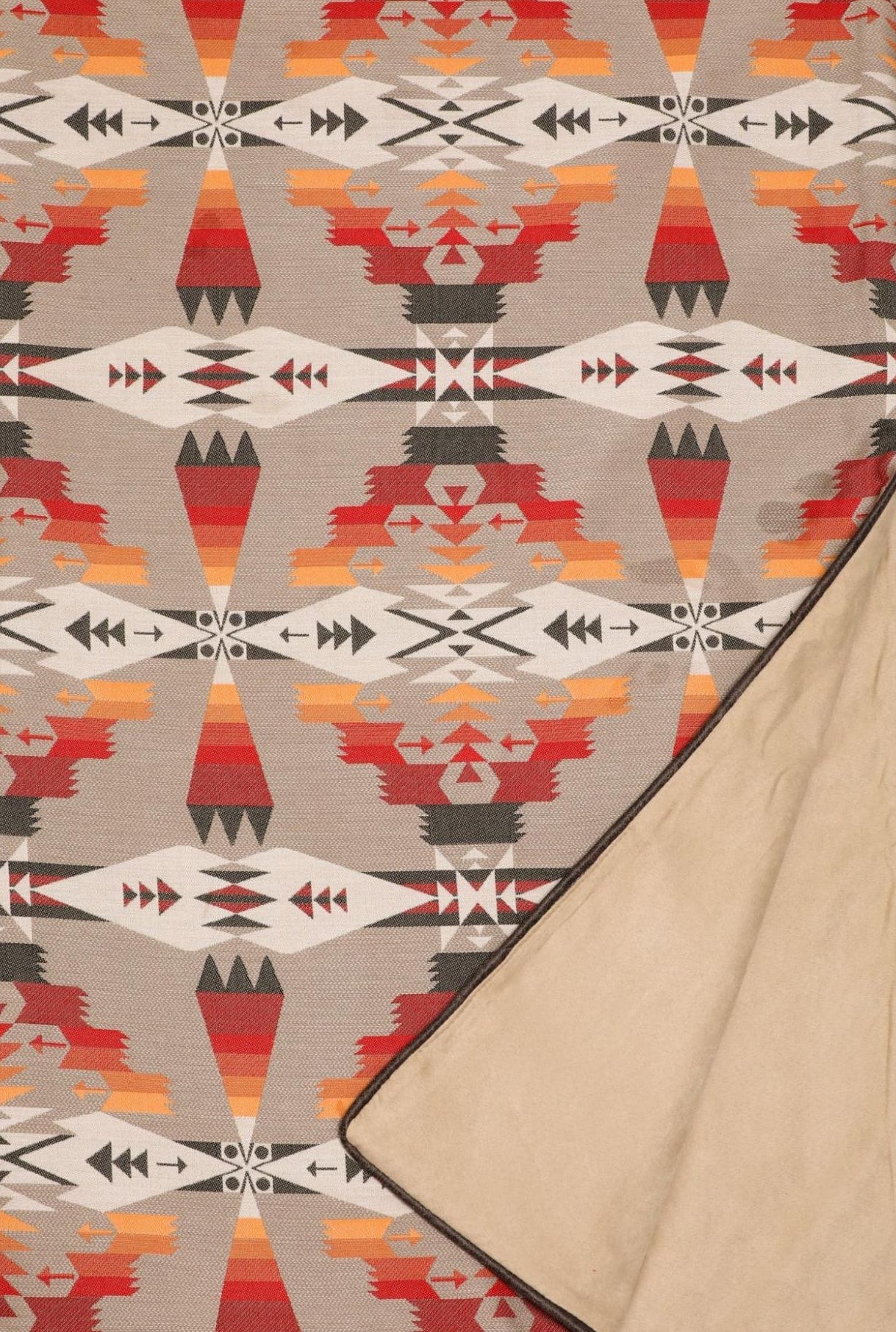 Patterned blanket with geometric design on a beige background