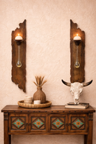 Decorative wooden console table with wall candle sconces and a bull skull on a beige wall - Your Western Decor