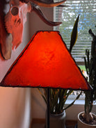 Amber square rawhide lamp shade with the lamp light on