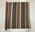 Striped fabric on the roll with brown, beige, and white colors on a grid background