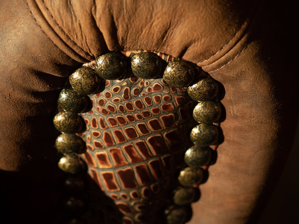 Detail of Smokey Lounge Arm Chair nail trim and croc embossed leather accent