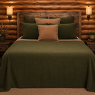 Solid olive green and brown coverlets and pillow shams in cabin styled bedroom 