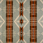 A close-up of a woven textile fabric pattern with a Southwestern geometric design. The color palette features a muted blue-gray base, vertical stripes in dark brown, rust red, and beige, and diamond motifs.