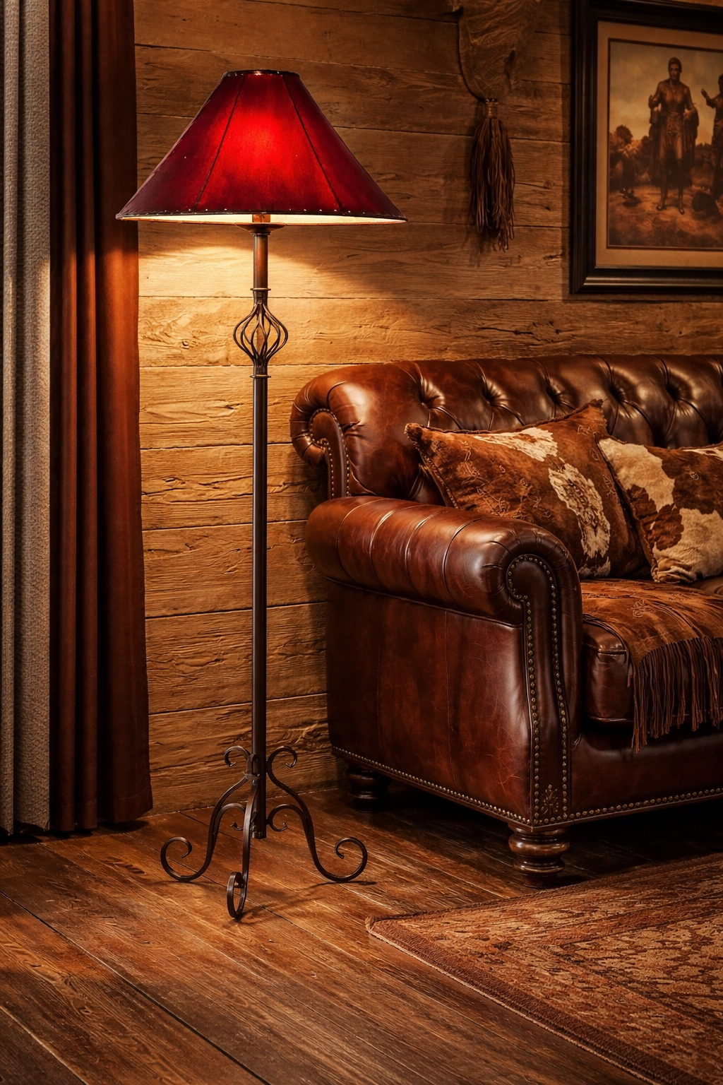 Brown leather sofa with decorative pillows next to an iron lamp with red rawhide lamp shade in a room with wooden walls - Your Western Decor
