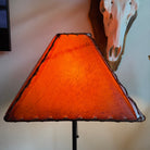 Square amber color rawhide lamp shade with light on 
