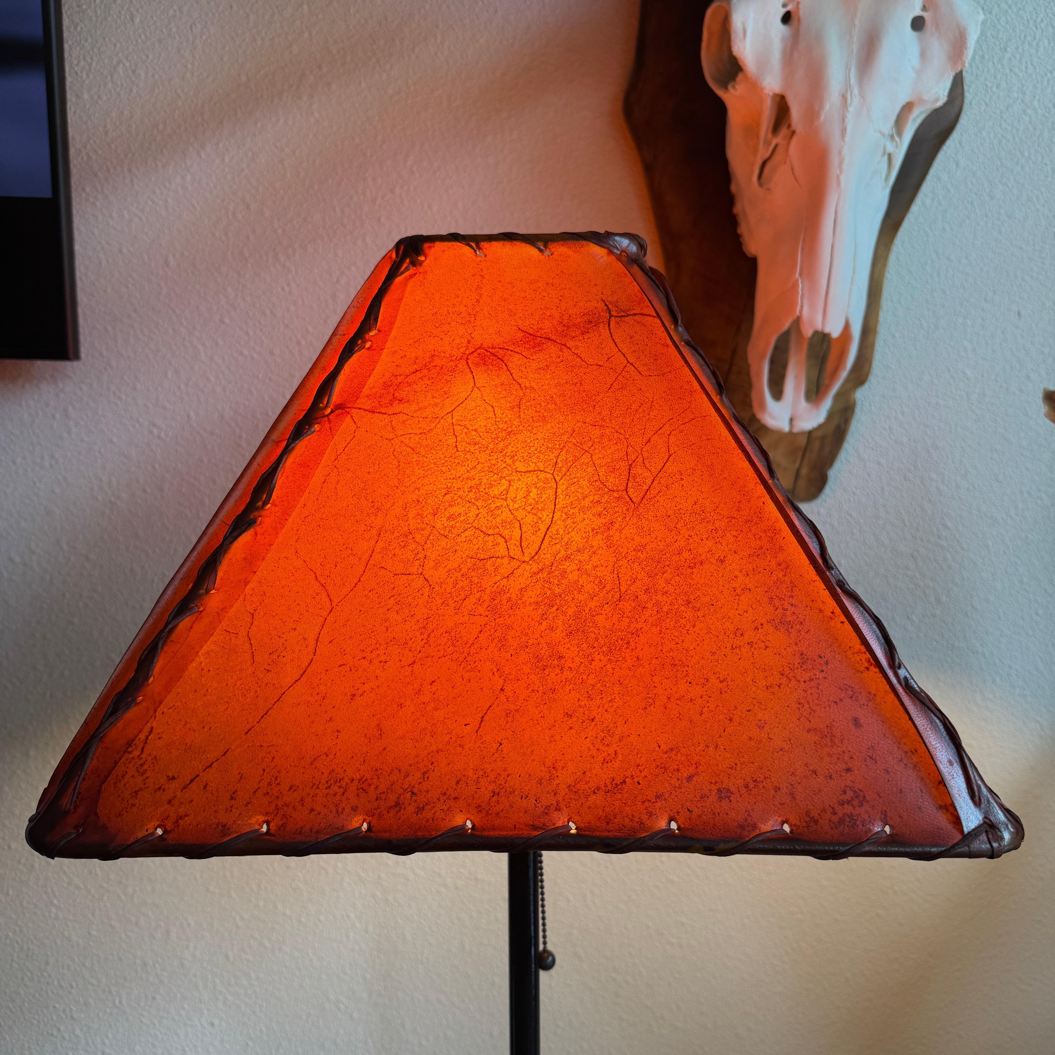 Square amber color rawhide lamp shade with light on 