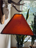 Square amber rawhide leather lamp shade with light off in natural lighting 