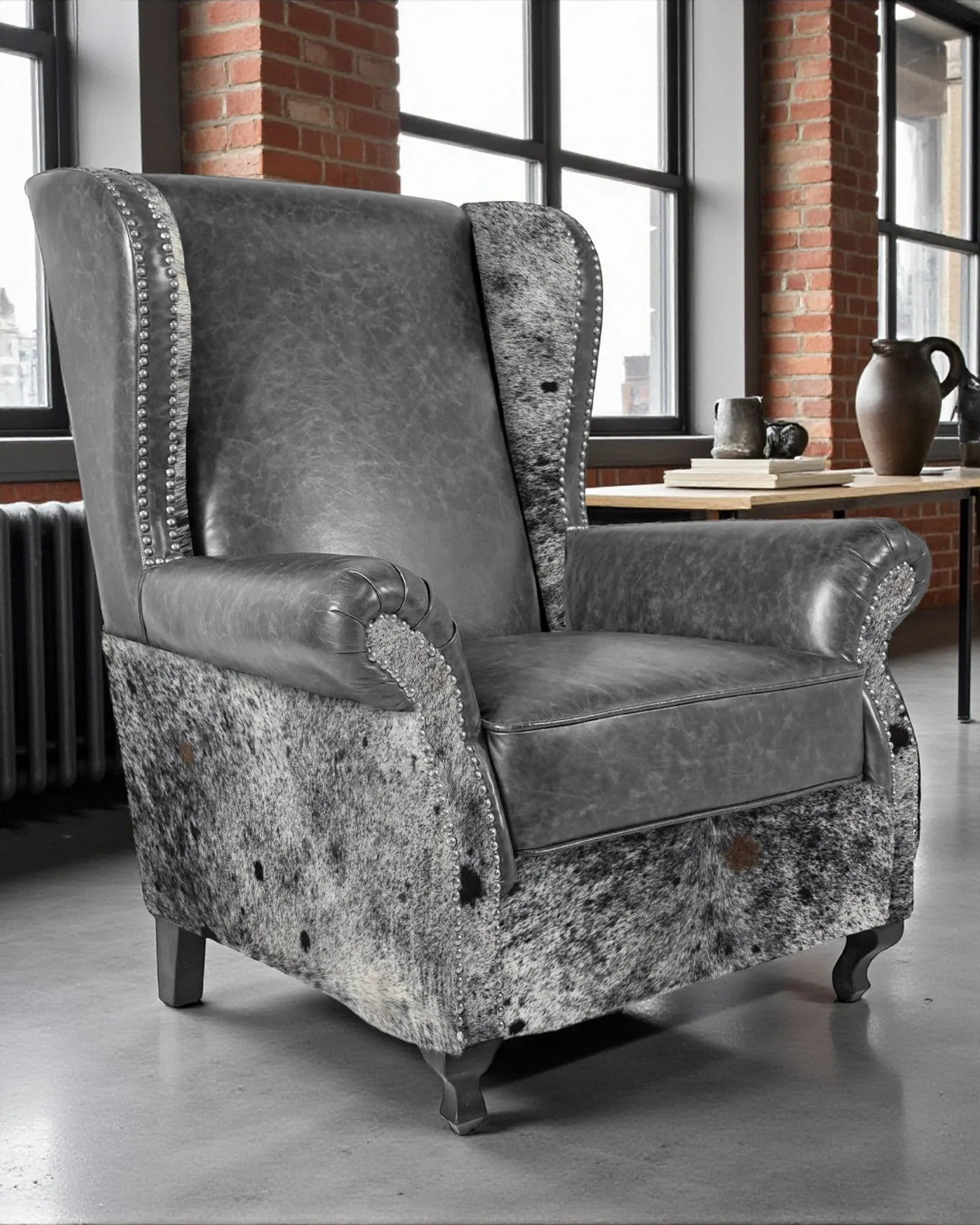 Gray armchair with patterned base in a room with large windows and brick walls - Your Western Decor