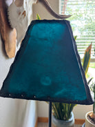 Teal rawhide leather lamp shade unlit in natural lighting 