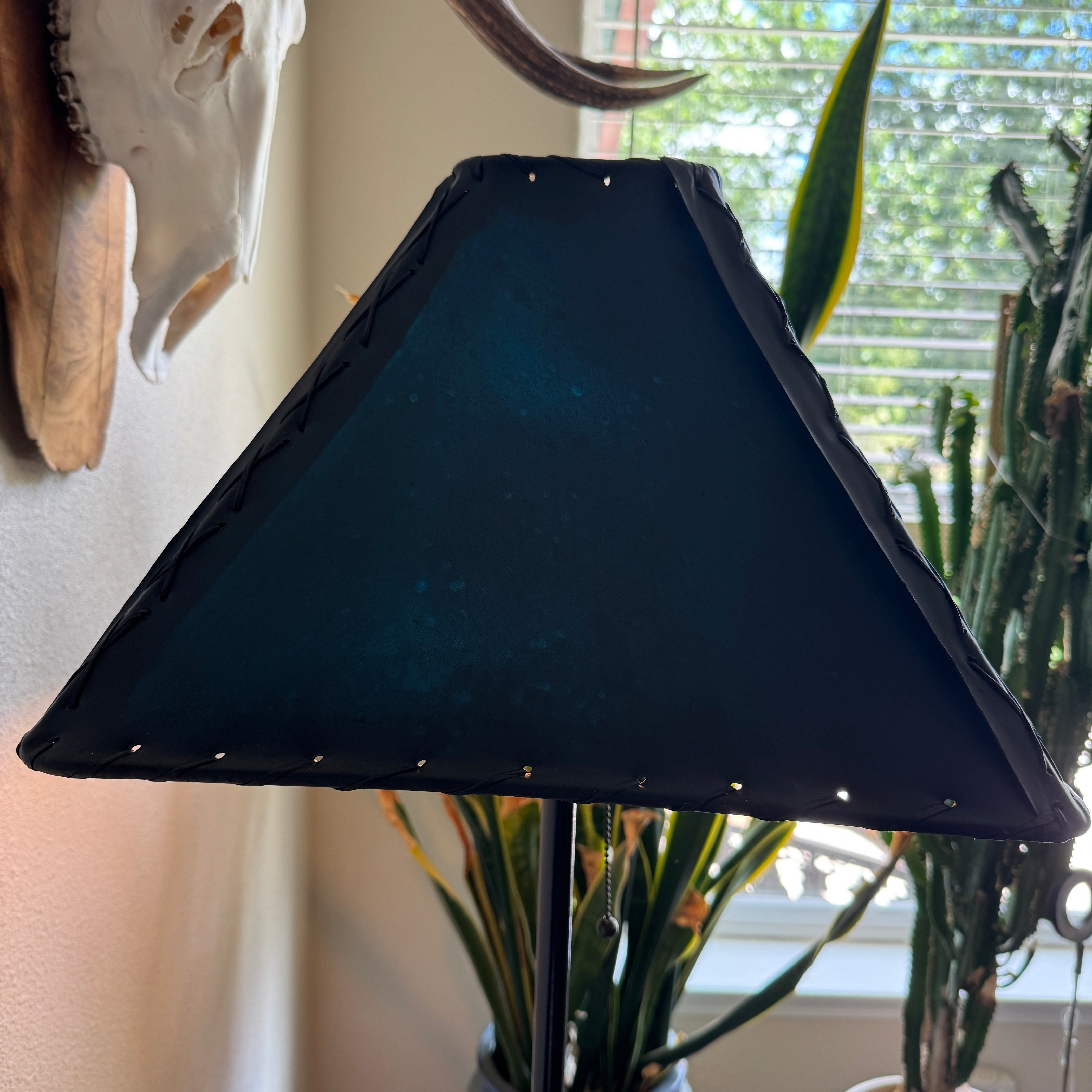 Teal rawhide square lamp shade not lit in natural lighting 