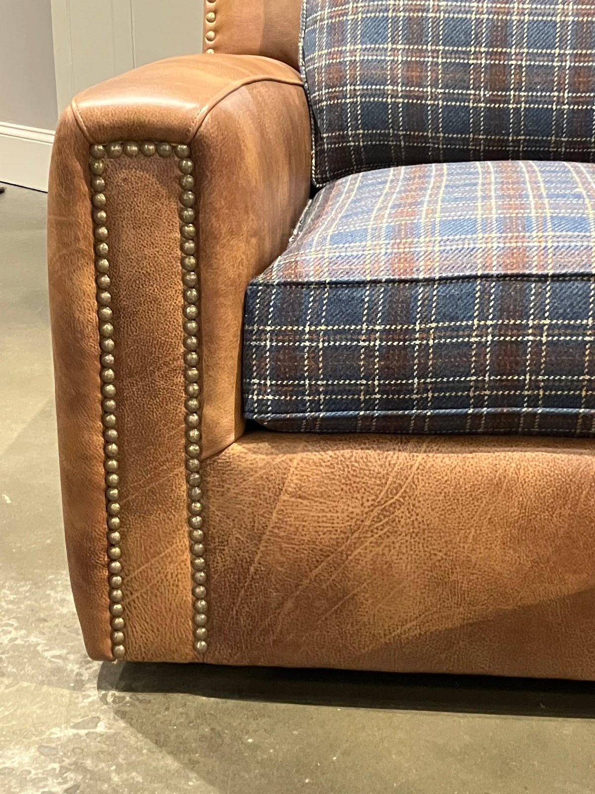 Close up of Teton plaid leather swivel chair with nail trim