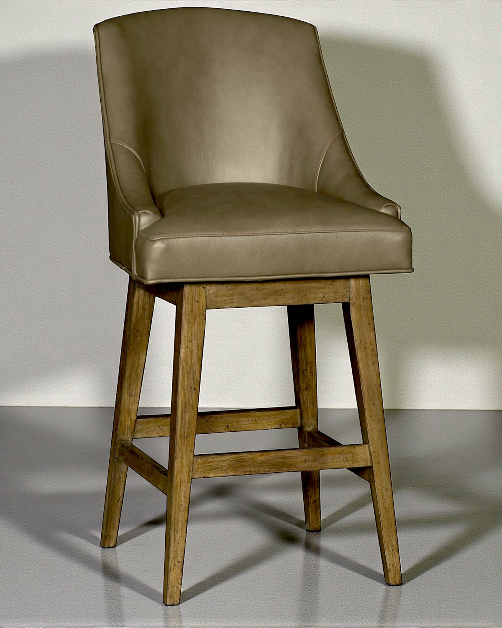 Brown leather bar stool with wooden legs on a gray background - YOur Western Decor