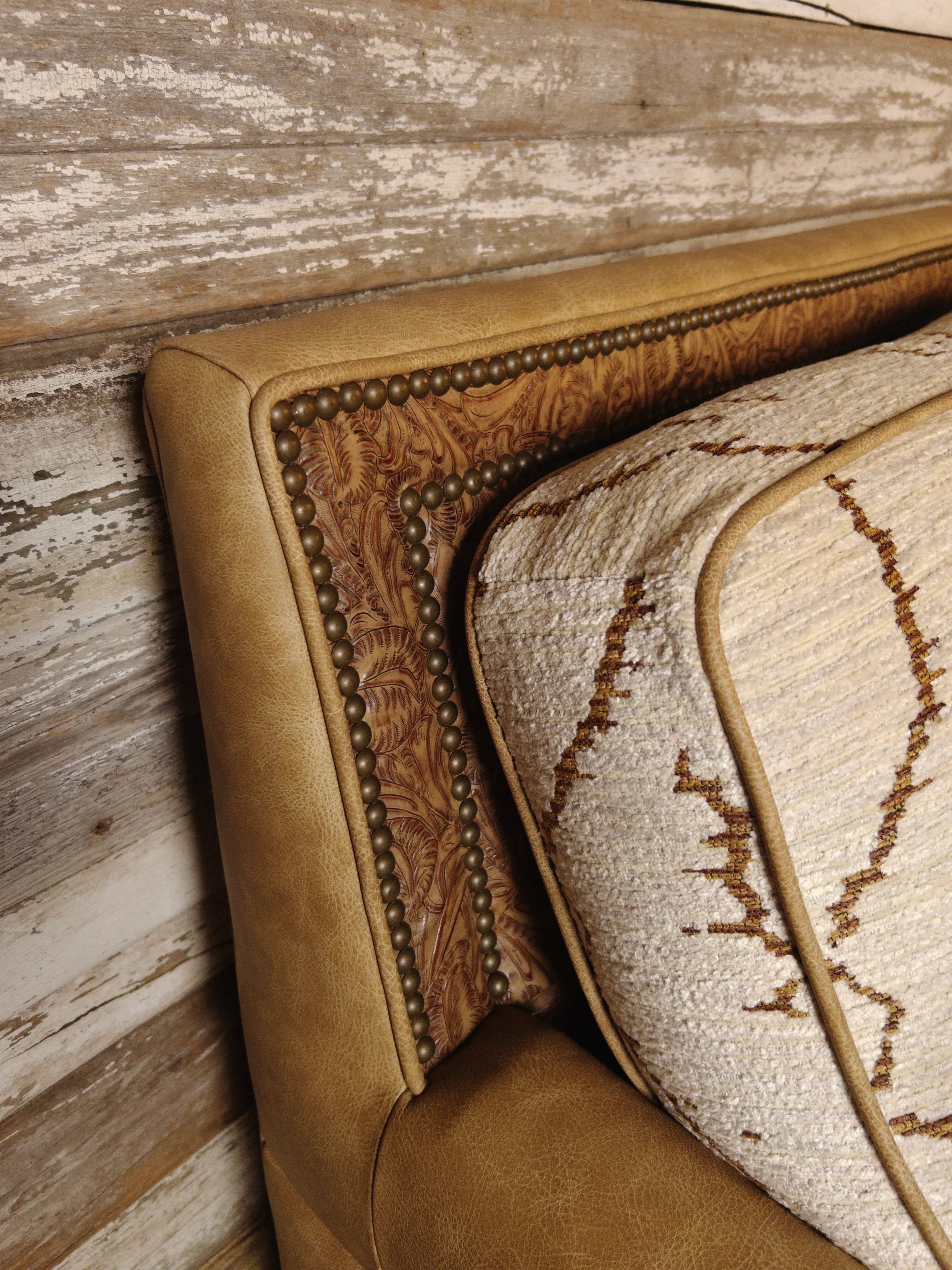Detail of top back corner of sofa showing smooth and western embossed leathers with 2 rows of nailhead trim 