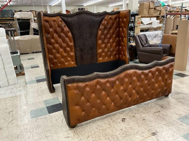 Brown tufted leather bed frame in a warehouse setting