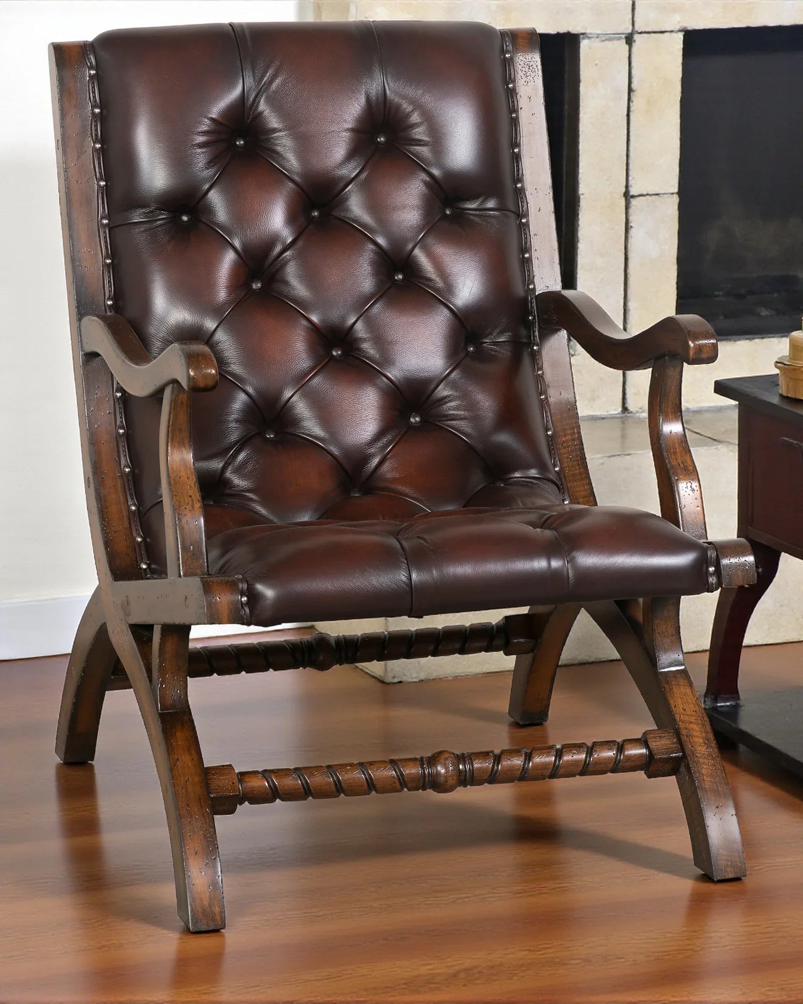 burnished leather tufted reading chair with nailhead trim and wood frame in western ranch office setting