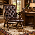 burnished leather tufted reading chair with nailhead trim in ranch office setting on Cowhide Spotted Vaquero Western Rug with wood desk and lamp