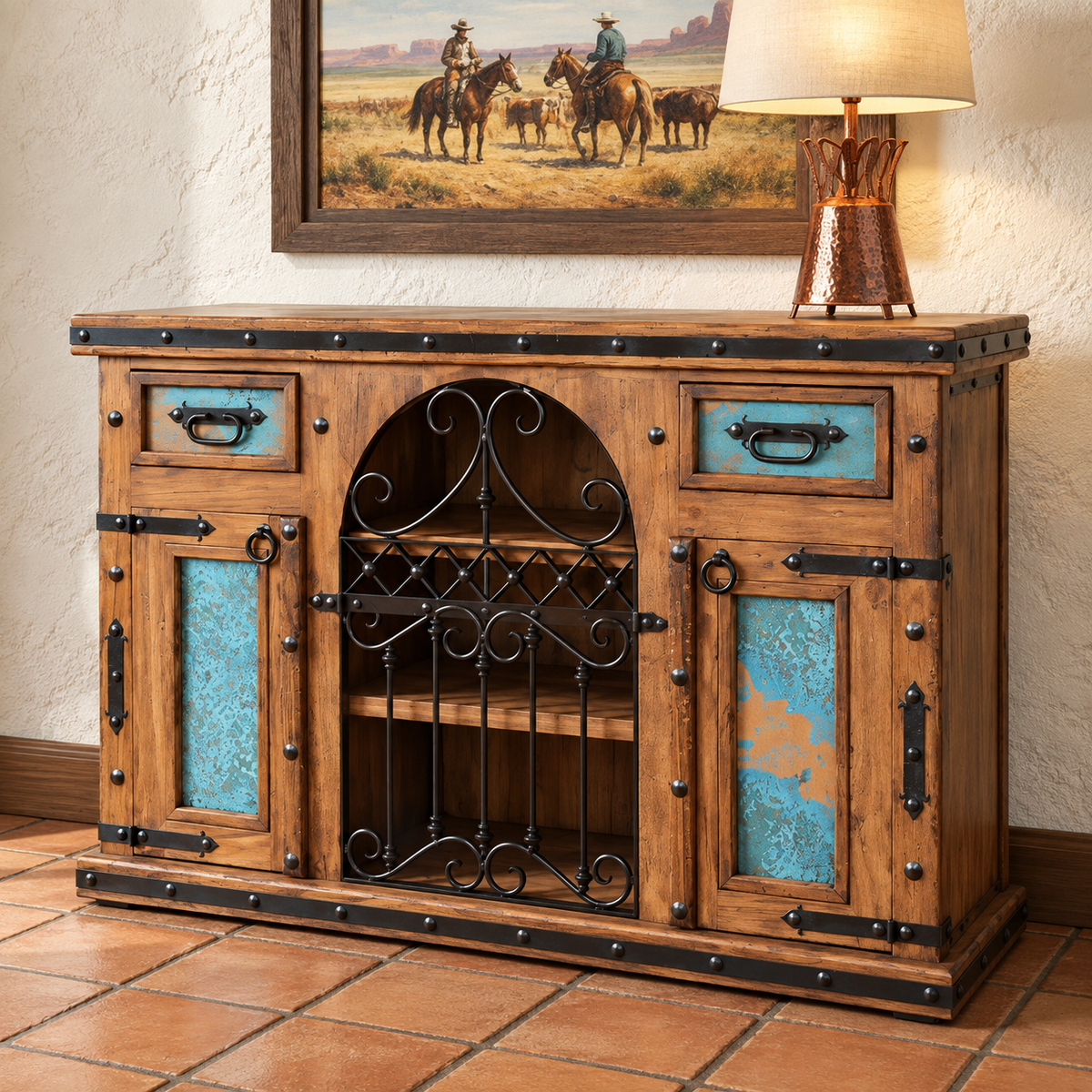 Rustic wooden sideboard cabinet with turquoise patina copper drawer fronts and decorative black metal hardware, shown in a styled interior setting with a lamp and framed artwork on a wall.