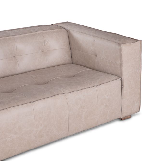 Close up of tufted Sierra Grande leather sofa with tailored panel stitching and wide upholstered arms.