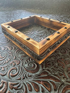 Back view of handmade coaster display box with embossed leather inside and handmade embossed leather belt