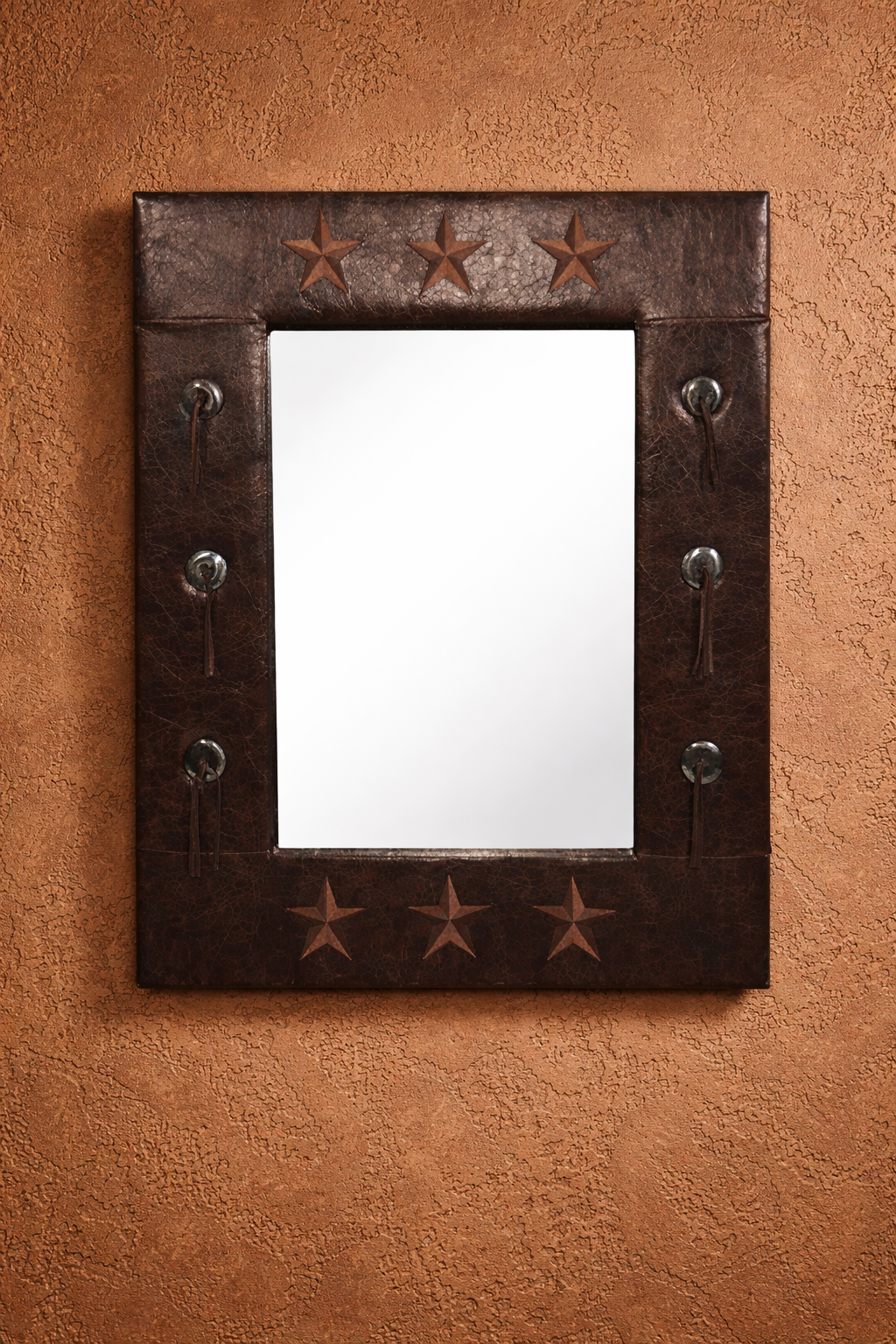 Decorative western mirror with star patterns on a brown textured wall - Your Western Decor