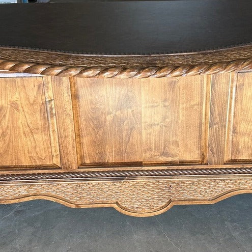 detail of carved western desk with leather surface 