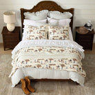 Bedroom with wooden bed, western range quilted bedding, and cowboy decor.