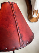 Close up of rawhide whip stitching on round red rawhide lamp shade
