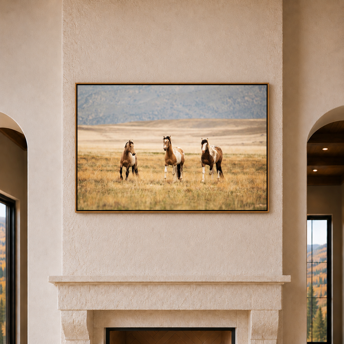 Framed canvas art showing three wild horses on the grassy plains with a tree covered mountain backdrop 