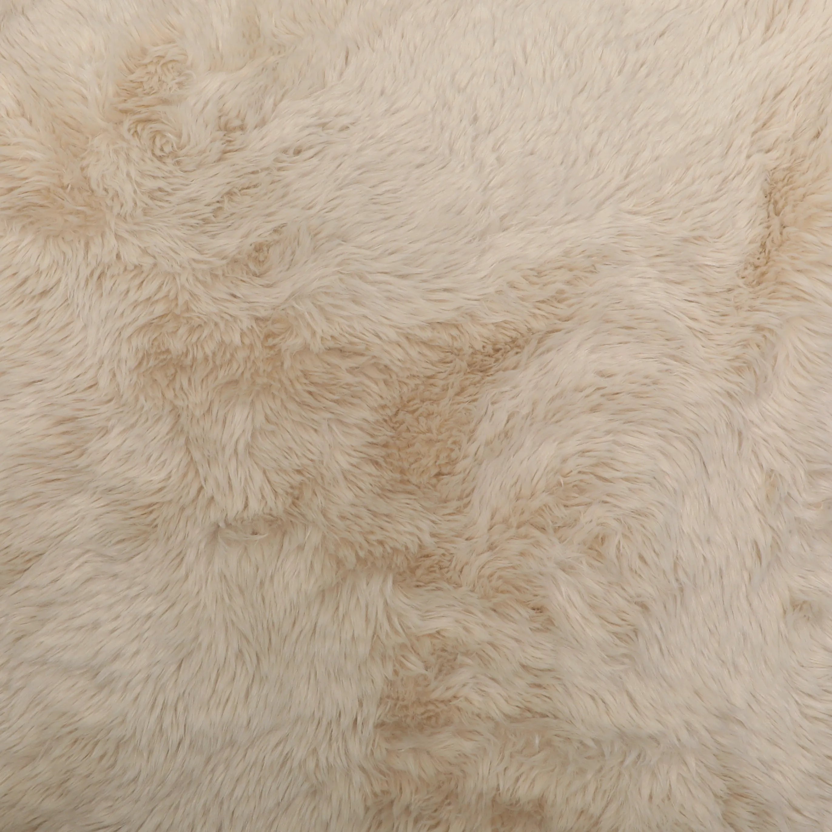 A close-up of a fluffy Yakety faux fur fabric  in a warm cream or off-white color, showing the soft texture and shaggy pile.