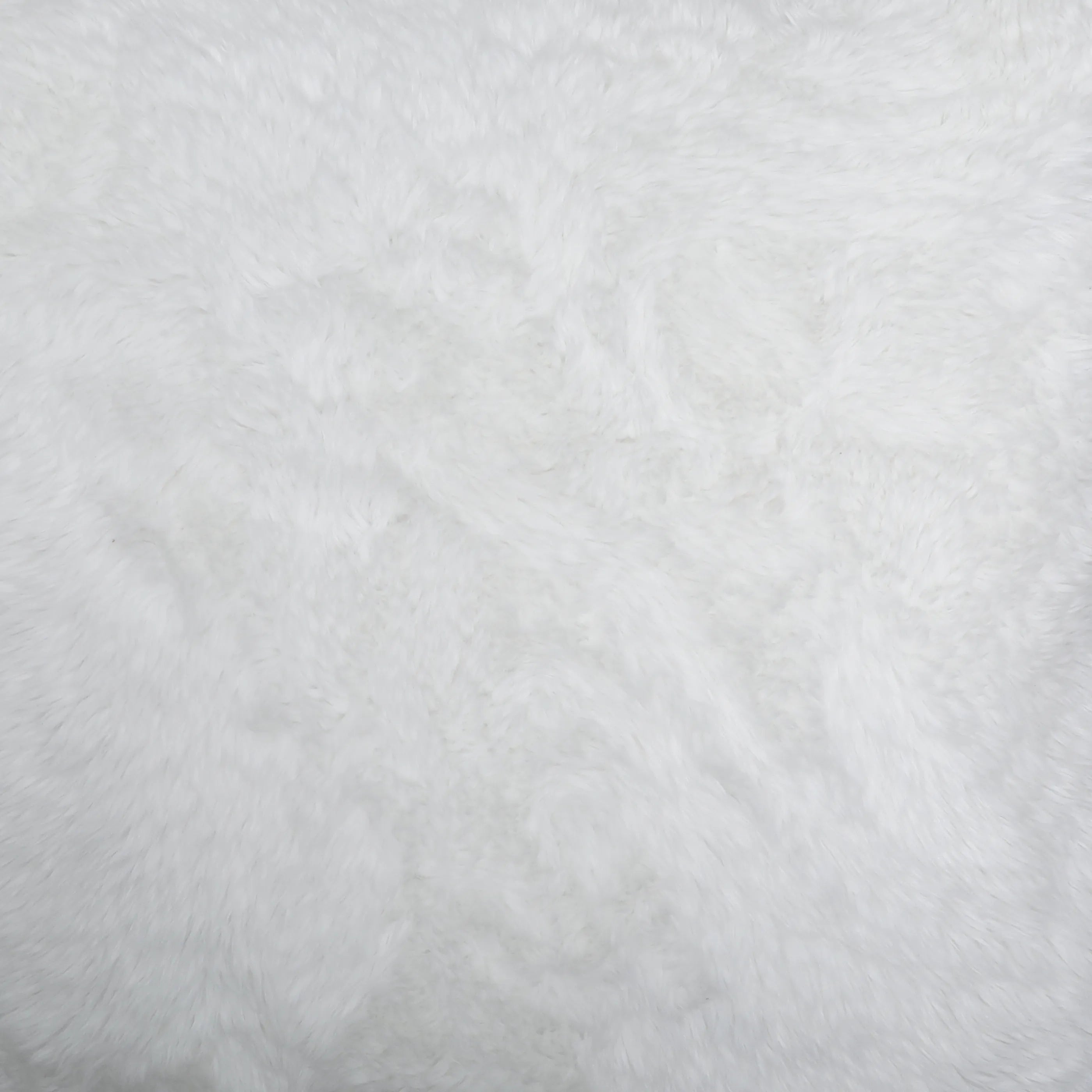White faux fur fabric texture closeup showing fluffy fibers and soft surface detail.