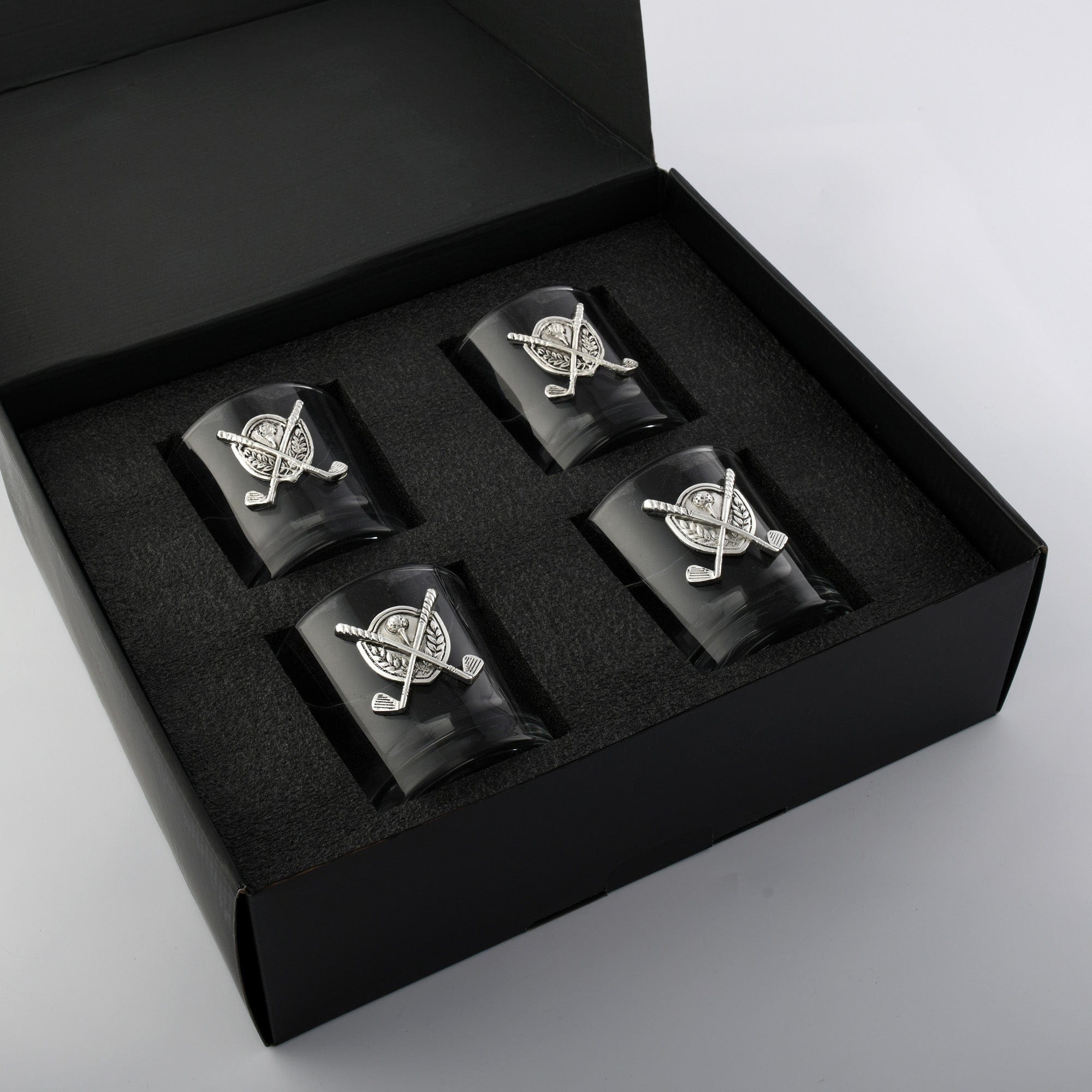 Set of four black containers with silver designs in a black box on a light gray background