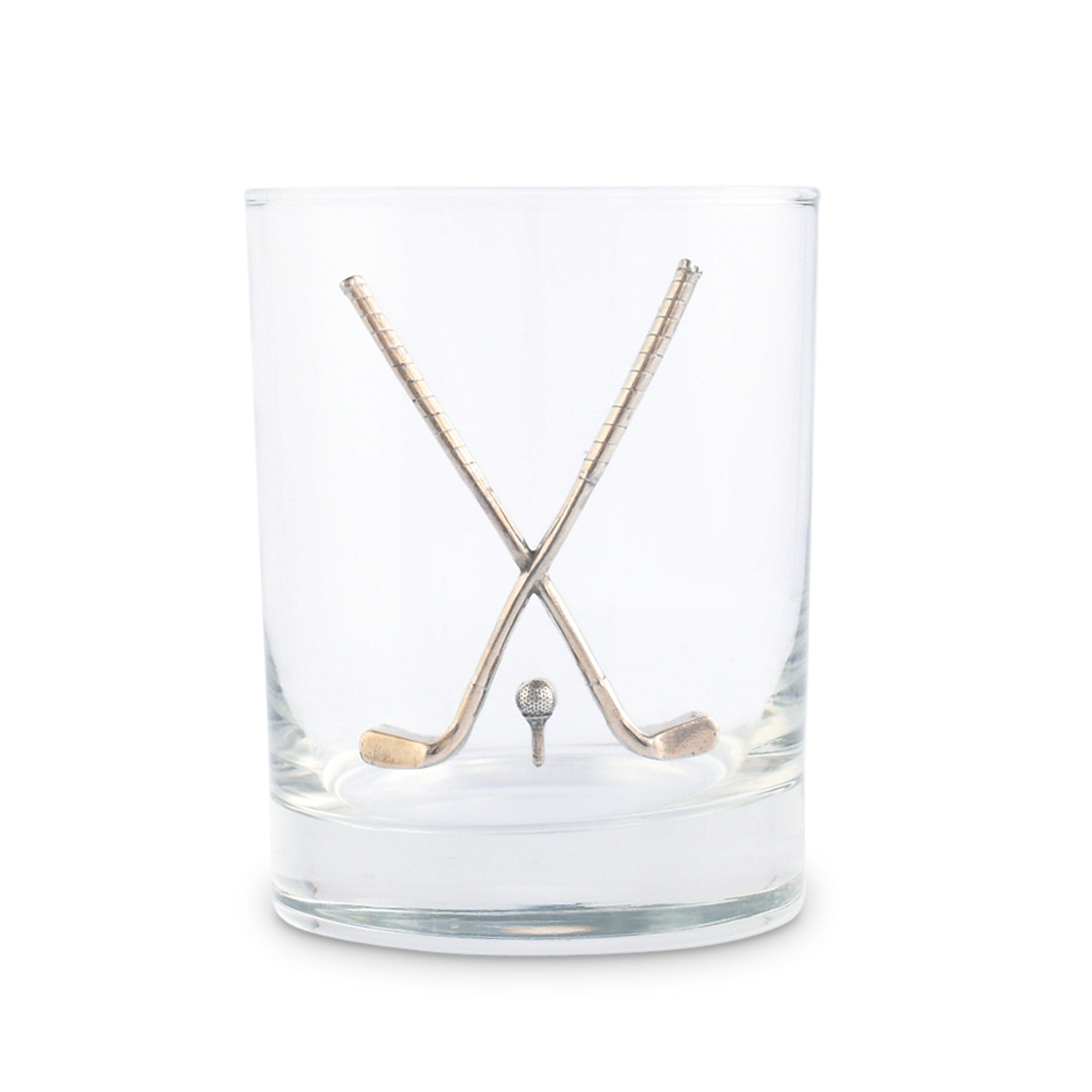 Clear glass tumbler with crossed golf clubs and a golf ball on a white background