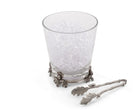 Decorative glass with a metal holder and tongs on a white background