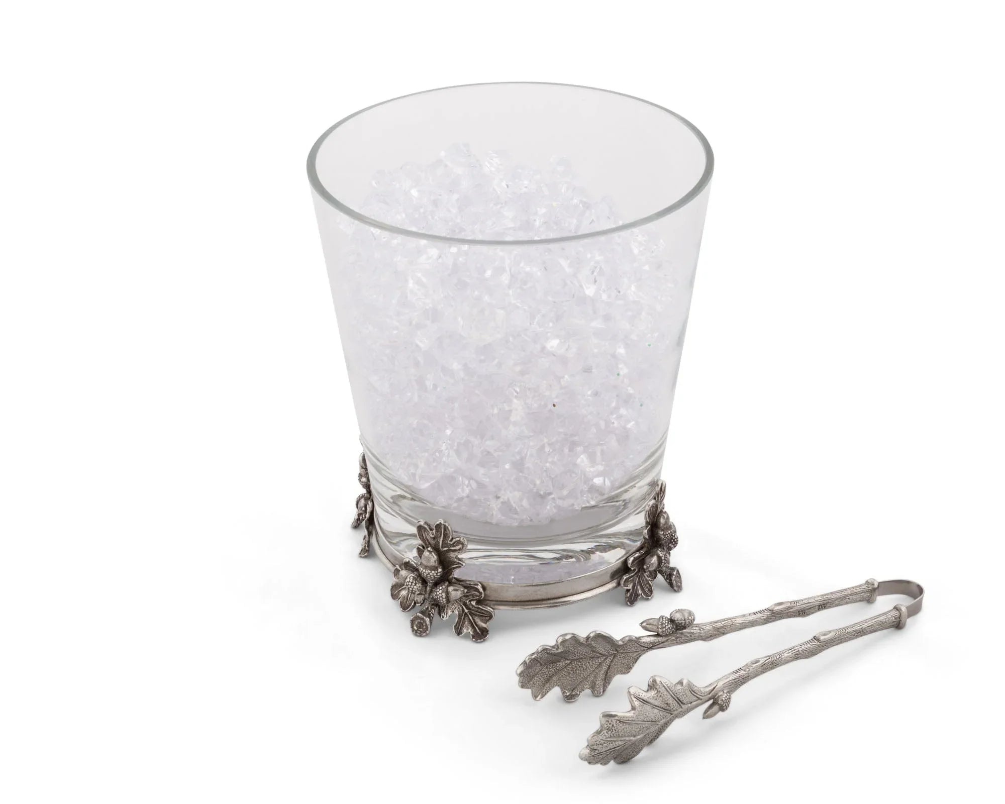Decorative glass with a metal holder and tongs on a white background