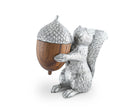 Silver squirrel salt shaker figurine holding a wooden pepper shaker acorn on a white background