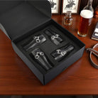 Set of four snaffle bit beer glasses in black box on a wooden table with a beer bottle and glasses in the background.