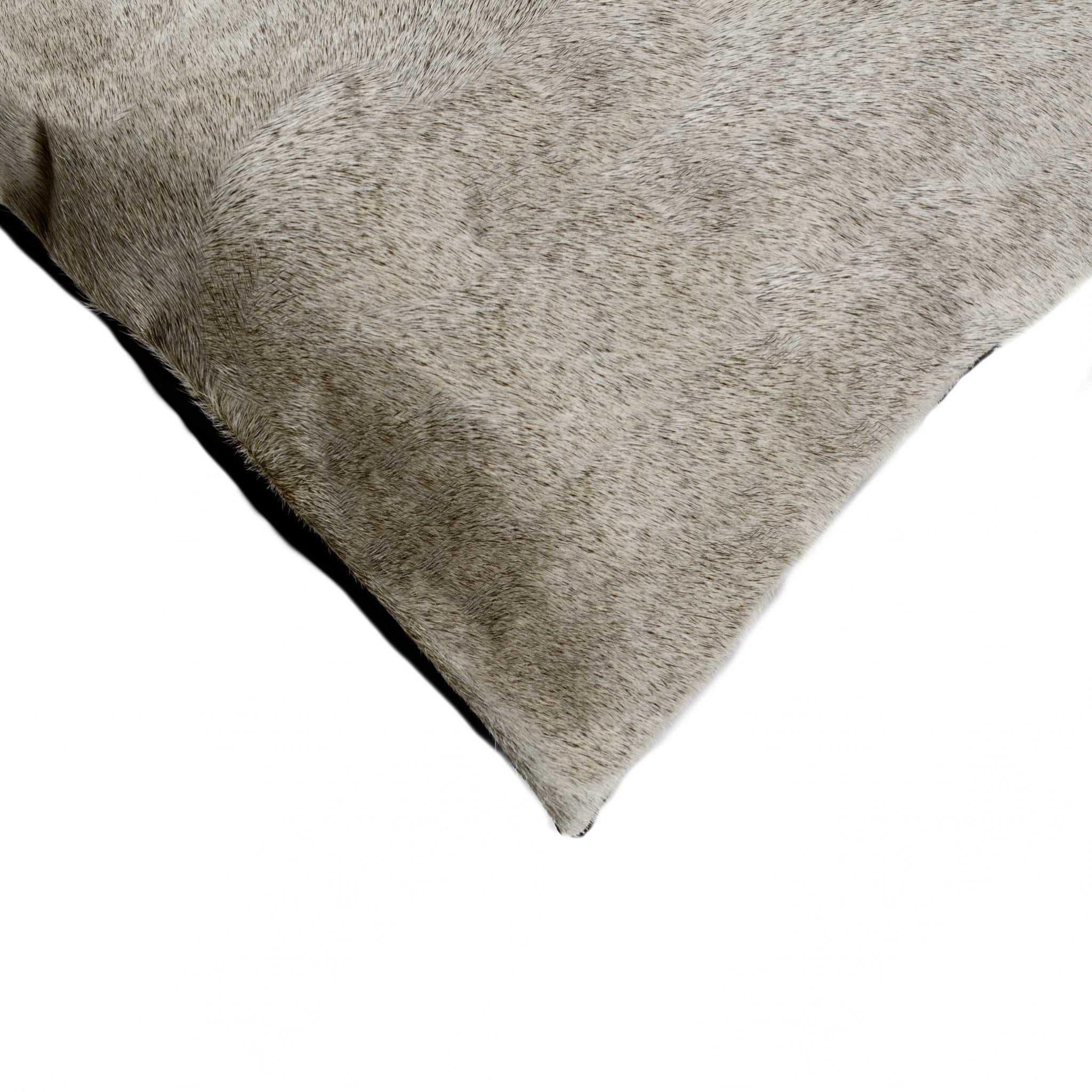 Detail of grey cowhide accent pillow corner 