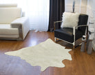 off white faux cowhide rug in modern western living room with leather chair hardwood floors and soft plush texture